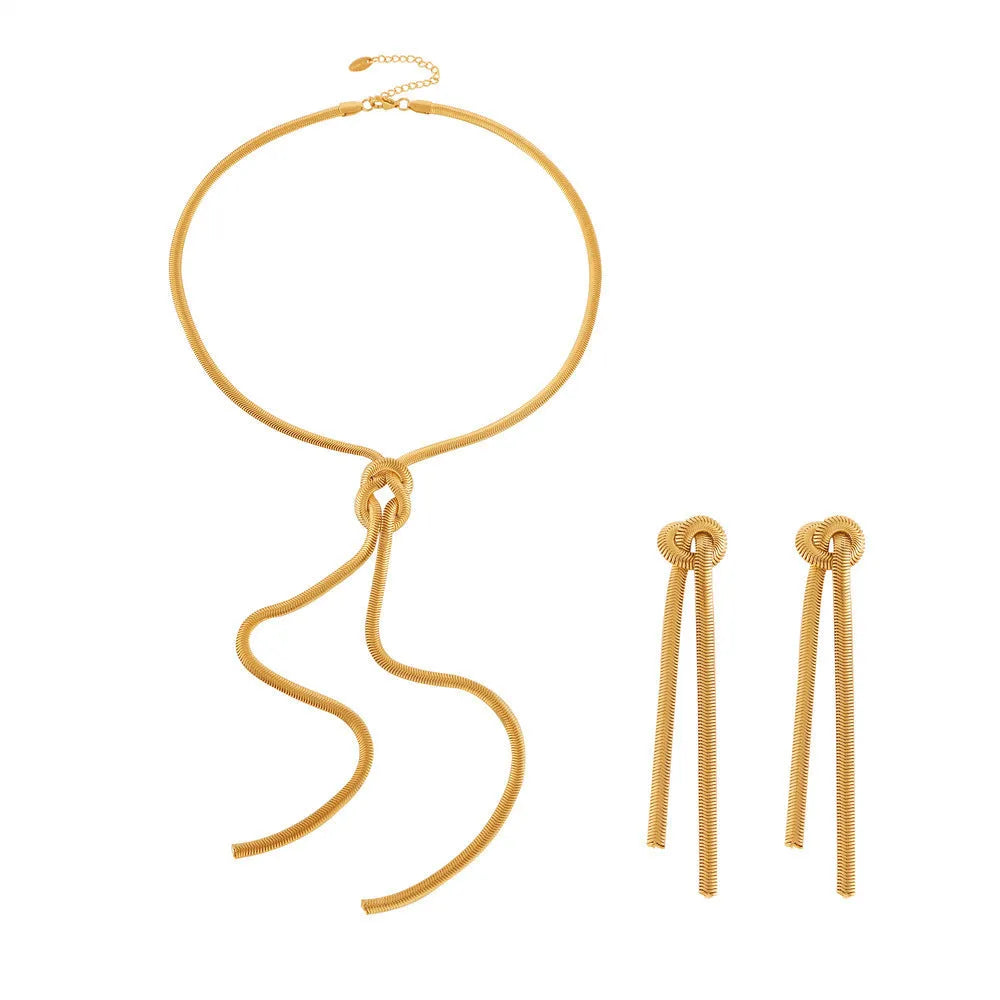 Gold colour titanium steel necklace with knotted tassel pendant and matching earrings on a white background.