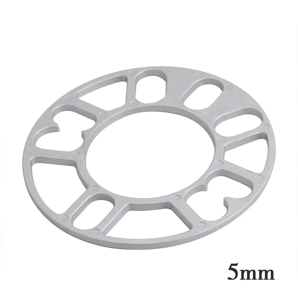 Hub centric wheel spacer kit for automotive modification in various thicknesses on a workshop bench.