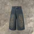 Men's black cropped denim shorts with flame embroidery patch detail on straight leg silhouette