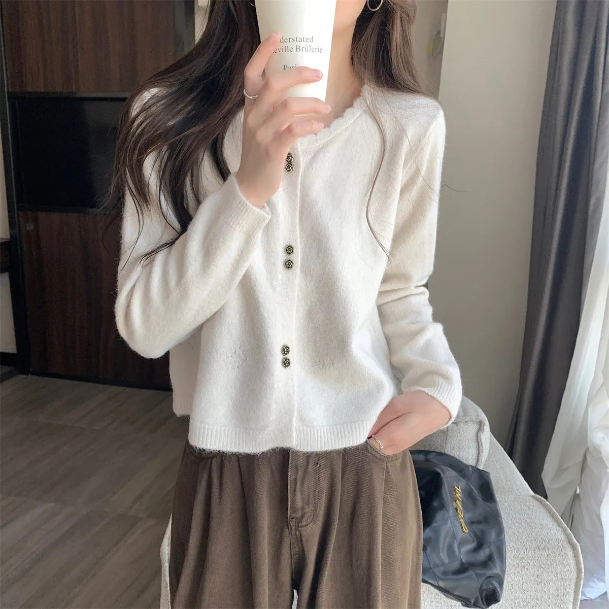 Women's milky white long-sleeved acrylic cardigan coat worn open as a layer.