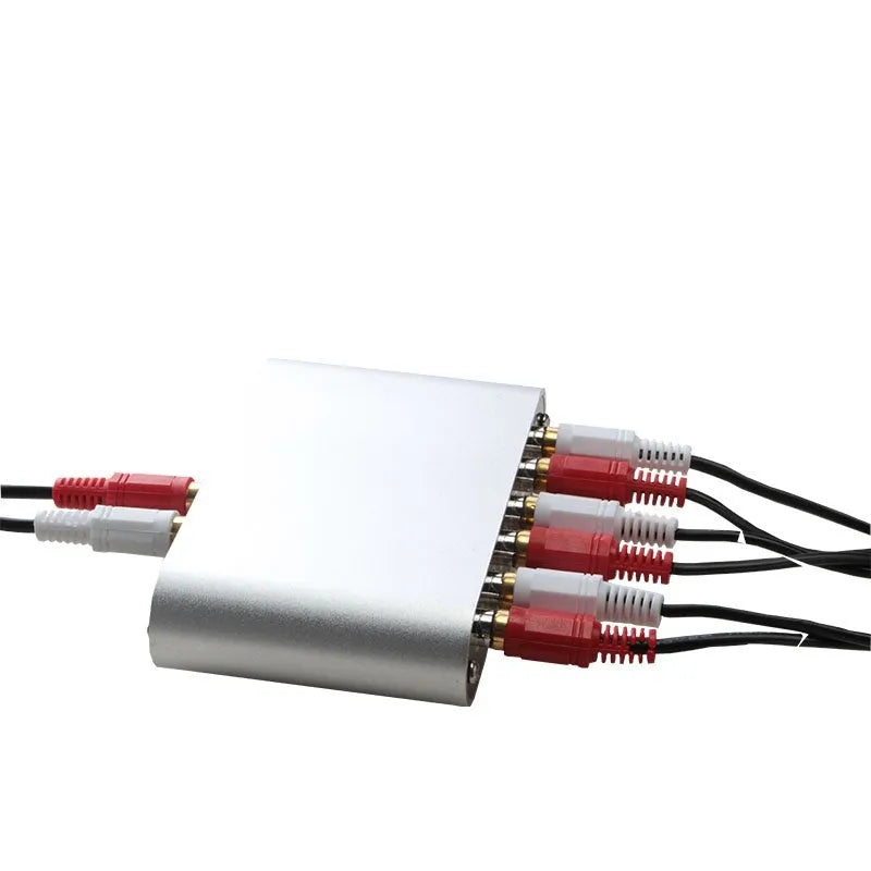 Silver audio source selector switch unit with infrared remote control for routing multiple audio signals.