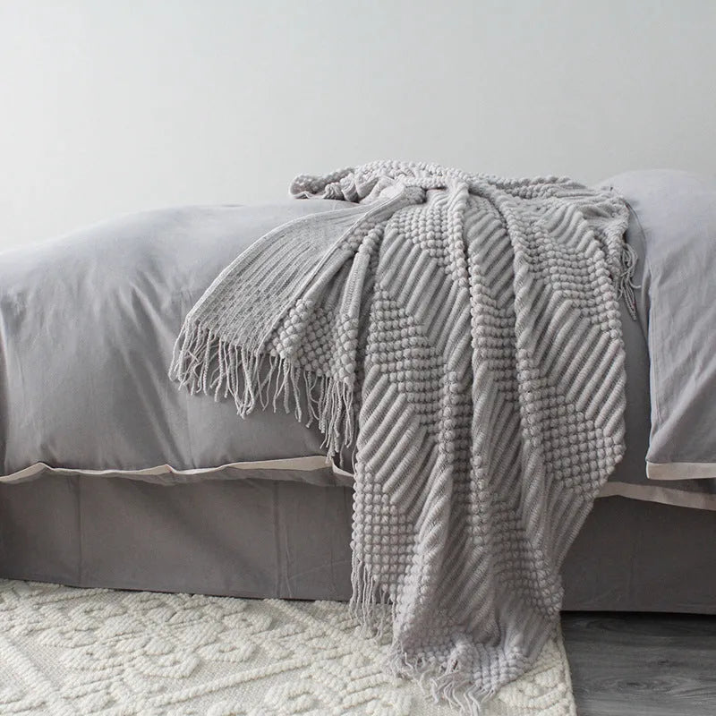 Small light grey polyester nap blanket folded, showing its size of 127 by 170 centimetres.