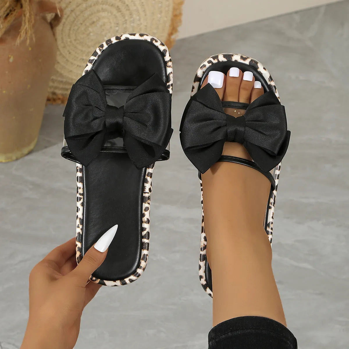 Women's black and white leopard print beach slippers with a thick sole and round toe design.