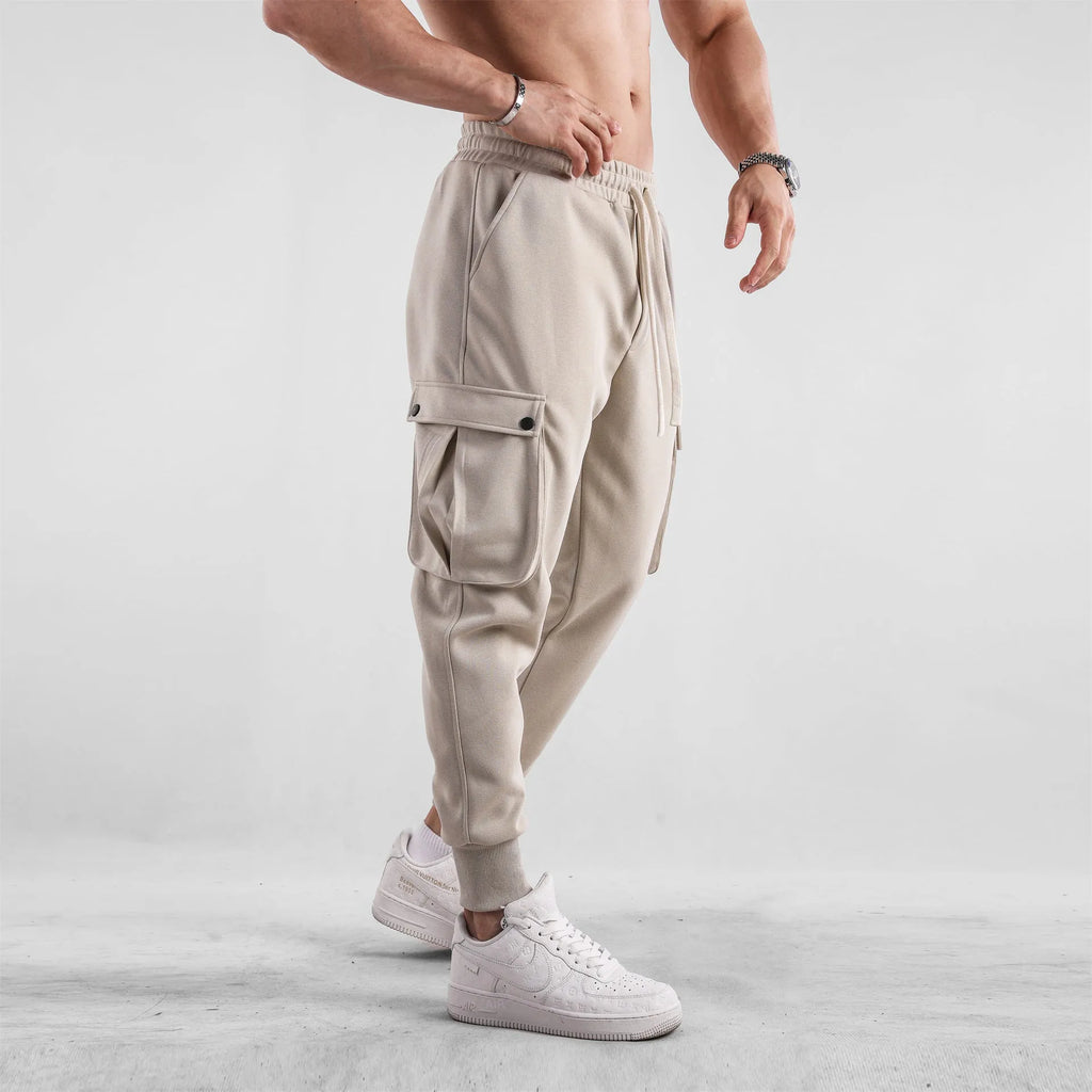 Men's loose cotton trousers with ankle ties and multiple pockets in a light grey colour