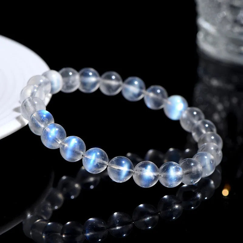Natural blue moonlight crystal bracelet with smooth beads on a plain background.