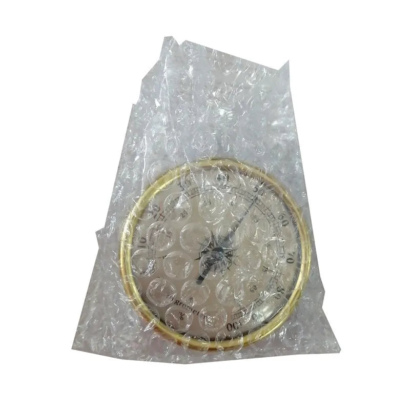 Silver analog hygrometer and thermometer with aluminium ring and dial showing temperature and humidity scales