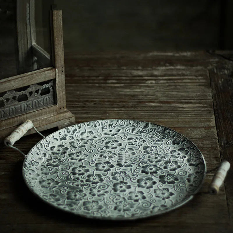 Round wrought iron storage trays in two sizes on a wooden surface