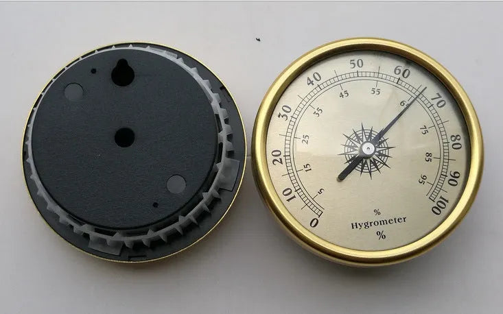 Silver analog hygrometer and thermometer with aluminium ring and dial showing temperature and humidity scales