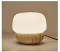 Cream coloured retro bedside lamp with a button switch on a wooden surface.