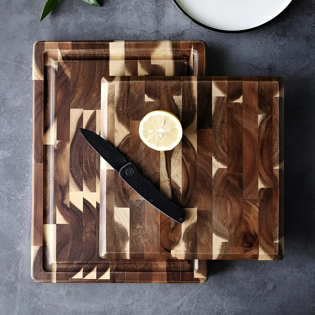 Brown acacia solid wood parquet cutting board with 3cm thickness on a kitchen counter.