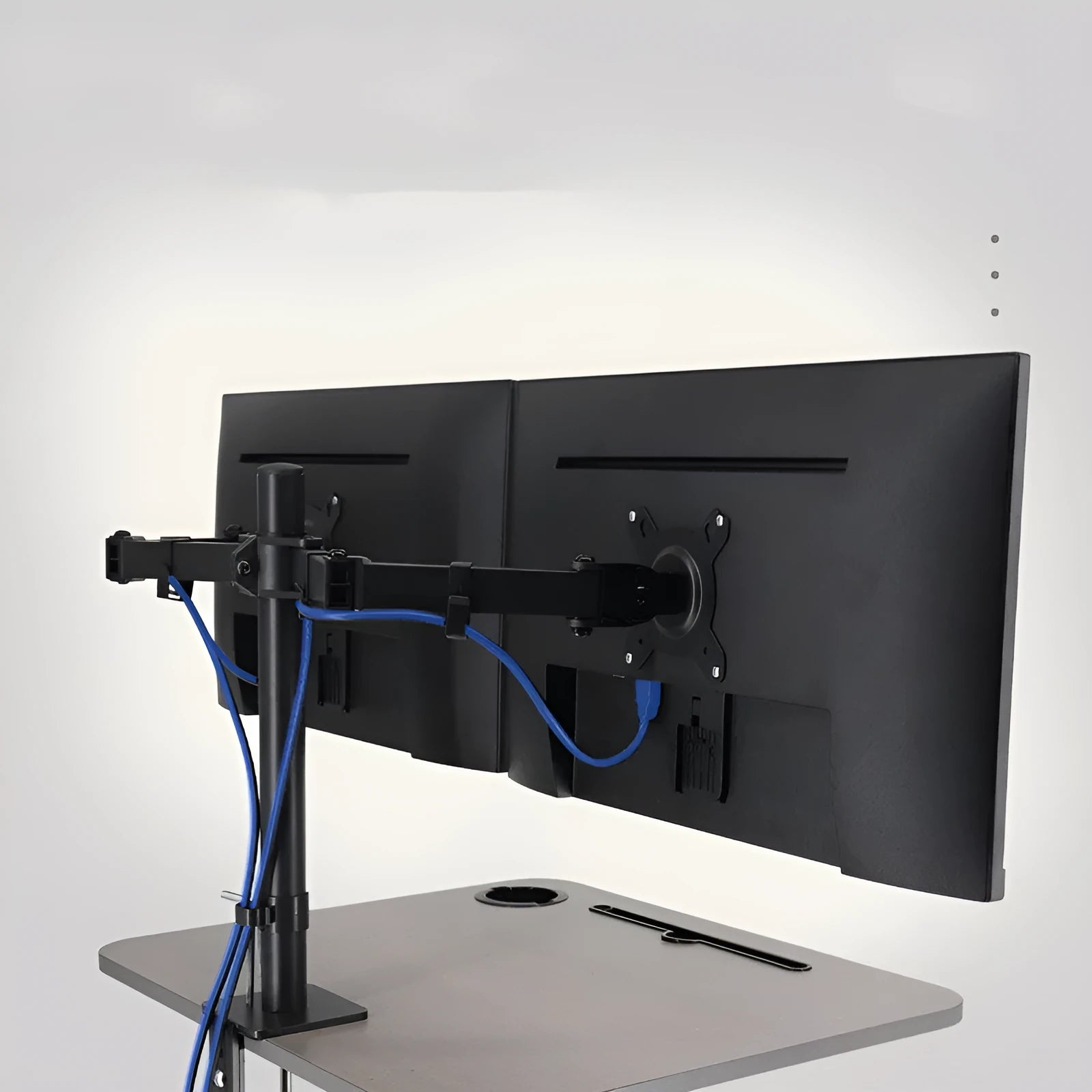 Black computer monitor lifting rotating bracket mounted on a desk, holding a widescreen display.