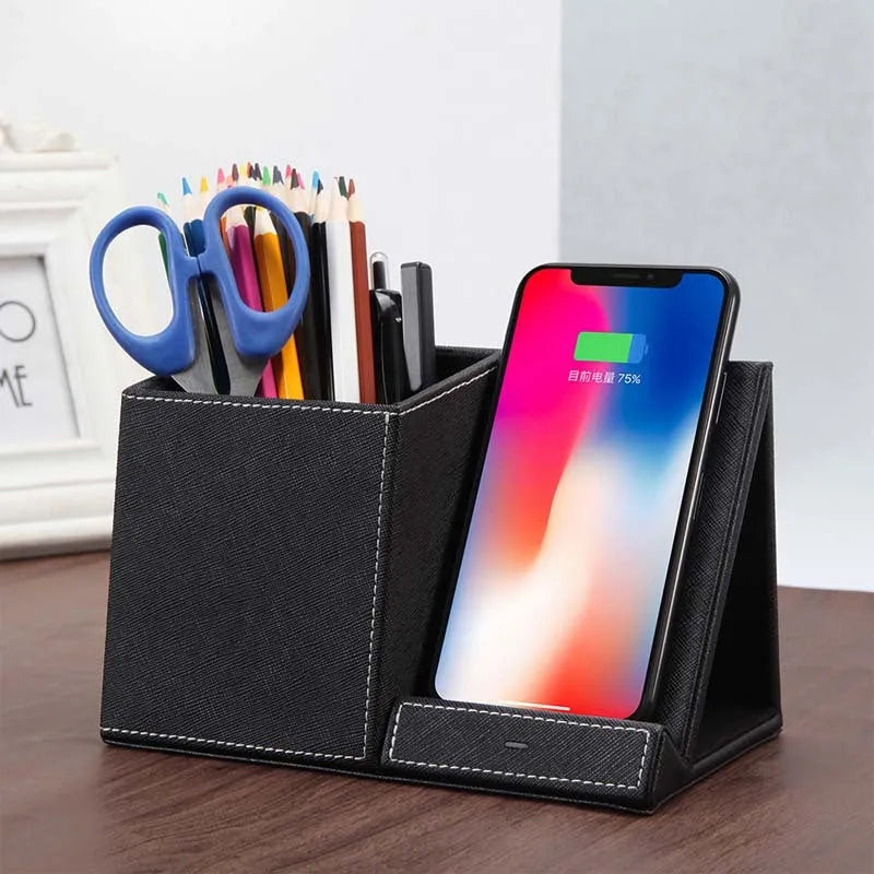 Black leather wireless charging station with built-in pen holder on a wooden desk.