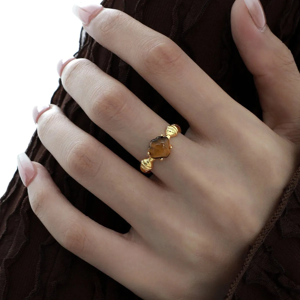 Adjustable silver women's ring with shell design in shell white or tiger eye finish.