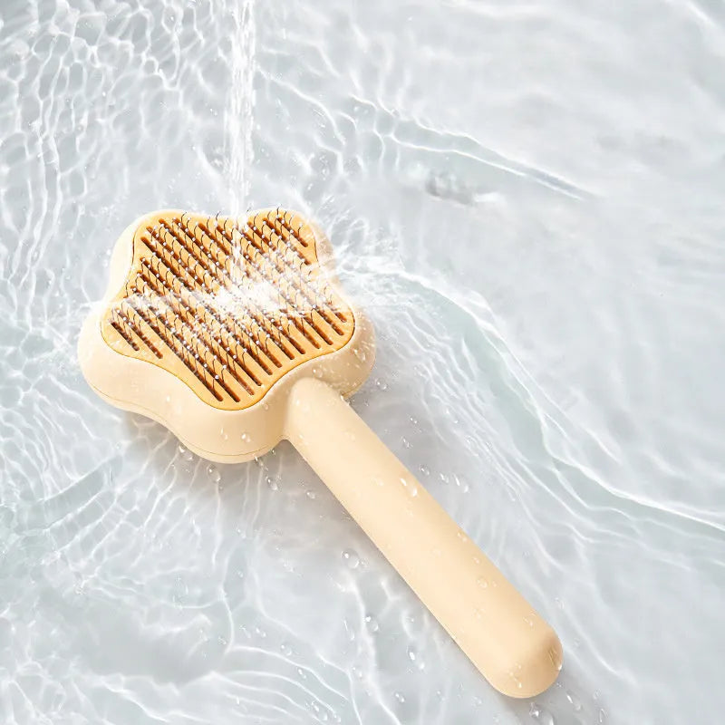 Green self-cleaning magic wand cat comb with stainless steel needle teeth on a white background.