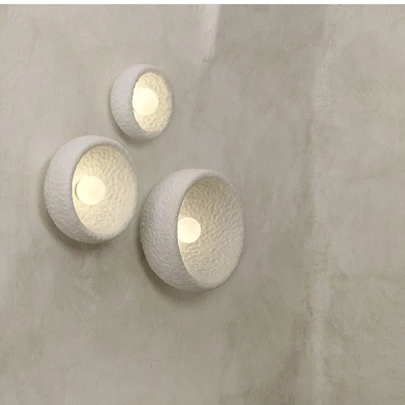 Japanese-style simple silent wall lamp with a white resin shade in three size diameters.