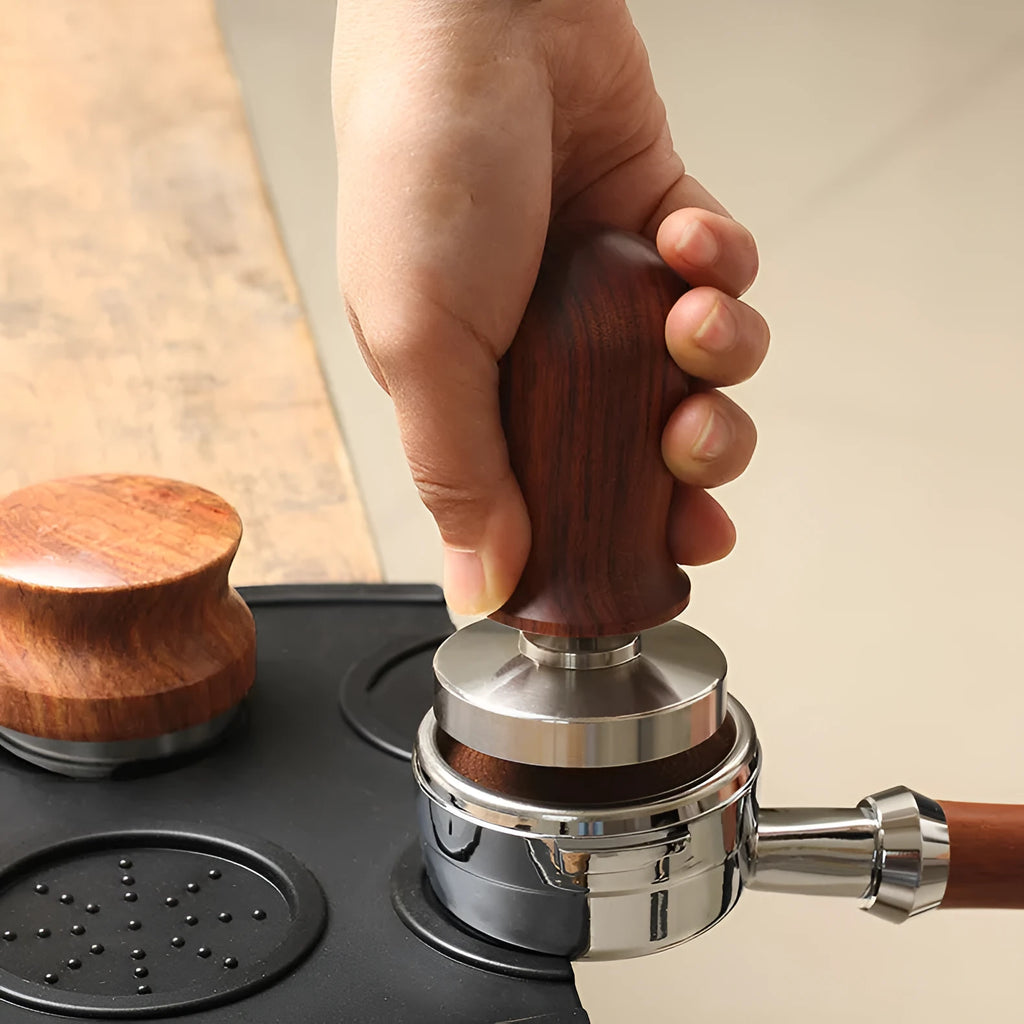 Black non-slip silicone coffee tamper pad with stainless steel base and integrated filling corner.