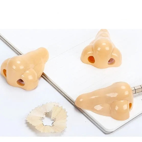 Flesh colour plastic geometry pencil sharpener with big nostril design on a white background.