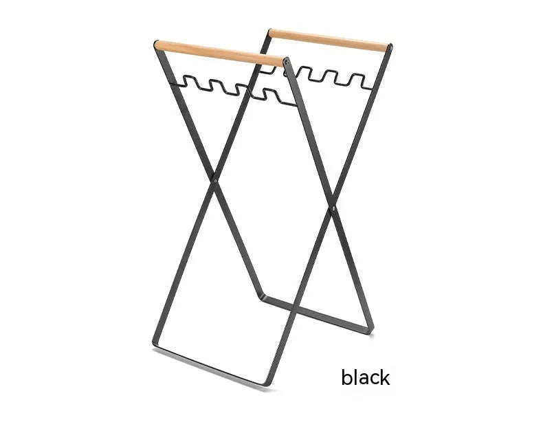 Black iron garbage storage hanger with wooden handle mounted on wall holding bin