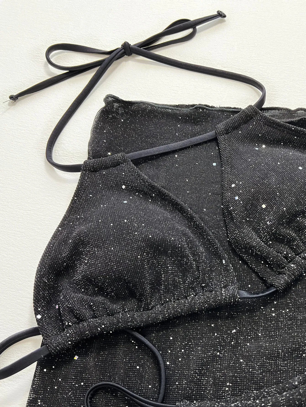 Black three-piece bikini swimsuit set with matching top and shorts