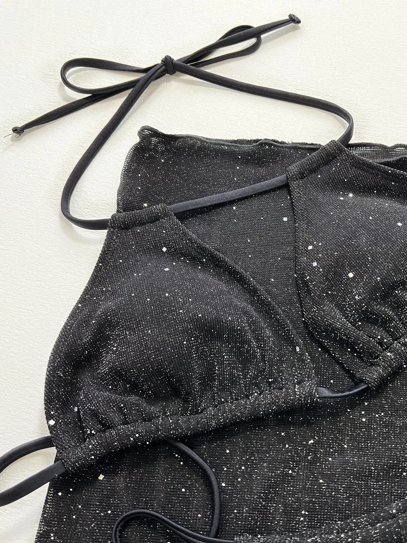 Black three-piece bikini swimsuit set with matching top and shorts