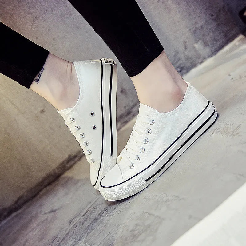 Women's solid-colour canvas shoes in black, shown on a foot from a side angle.