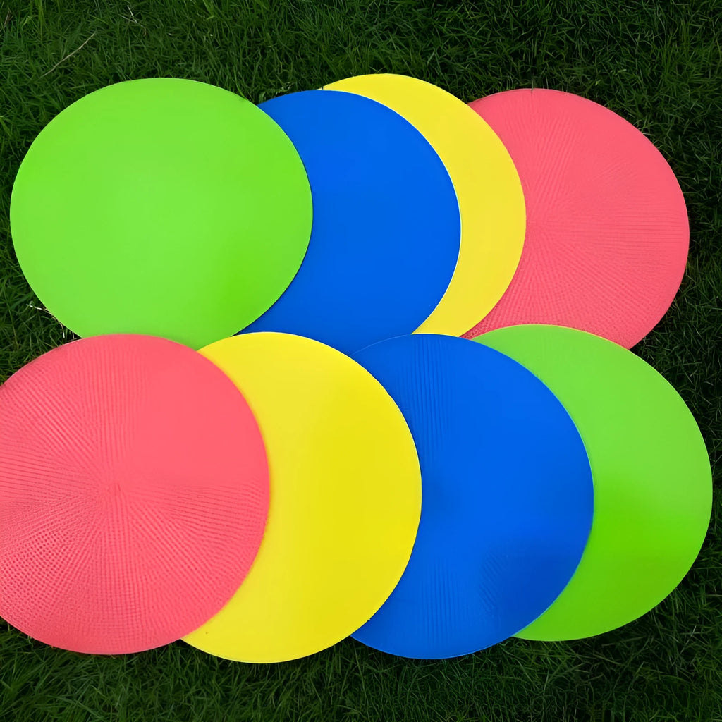 Yellow TPE football training marker disc lying flat on grass, 23cm diameter.
