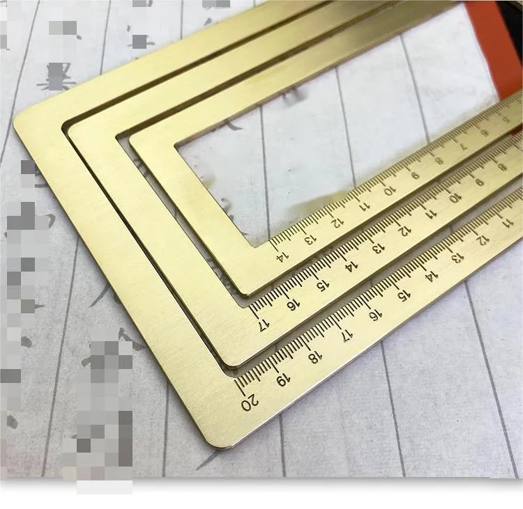 Square solid brass calligraphy paperweight with carved scale design on a wooden desk.