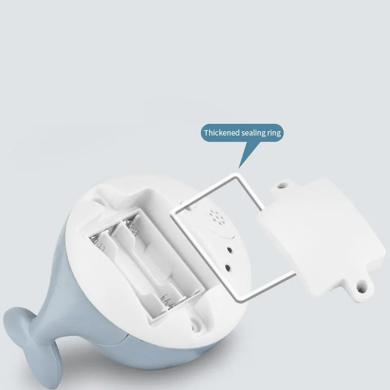 White and blue electric whale bath toy spraying water with flashing lights on base.