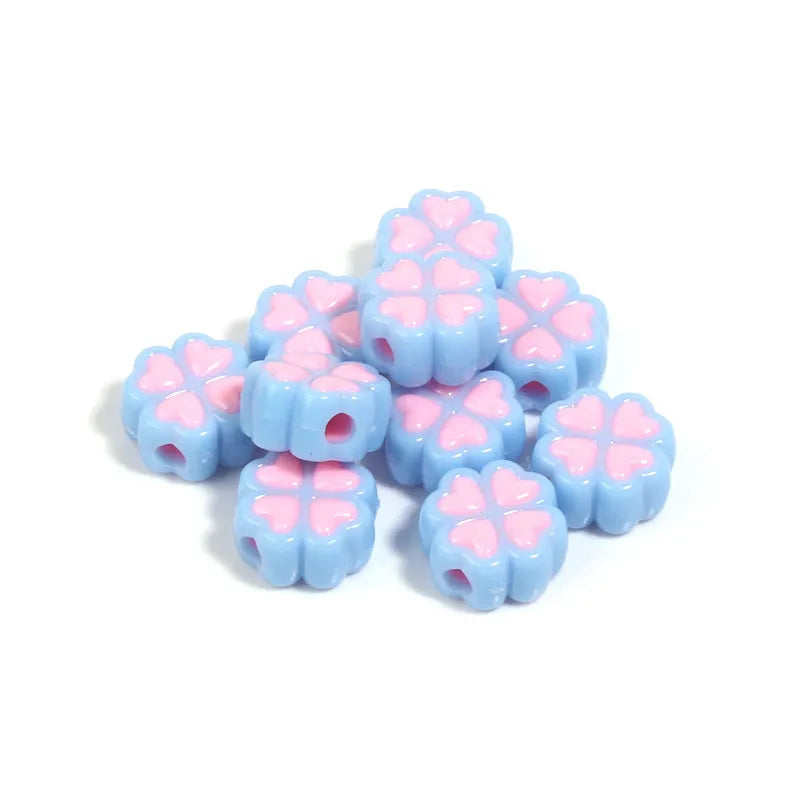 Assortment of frosted acrylic love clover beads in mixed colours on a white background.