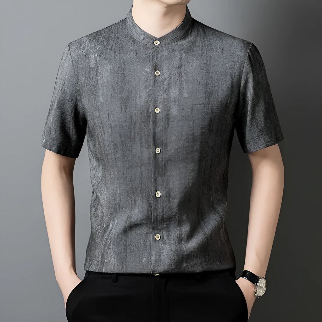 Man wearing a loose-fit black grey linen cardigan-style shirt with a stand collar and short sleeves.