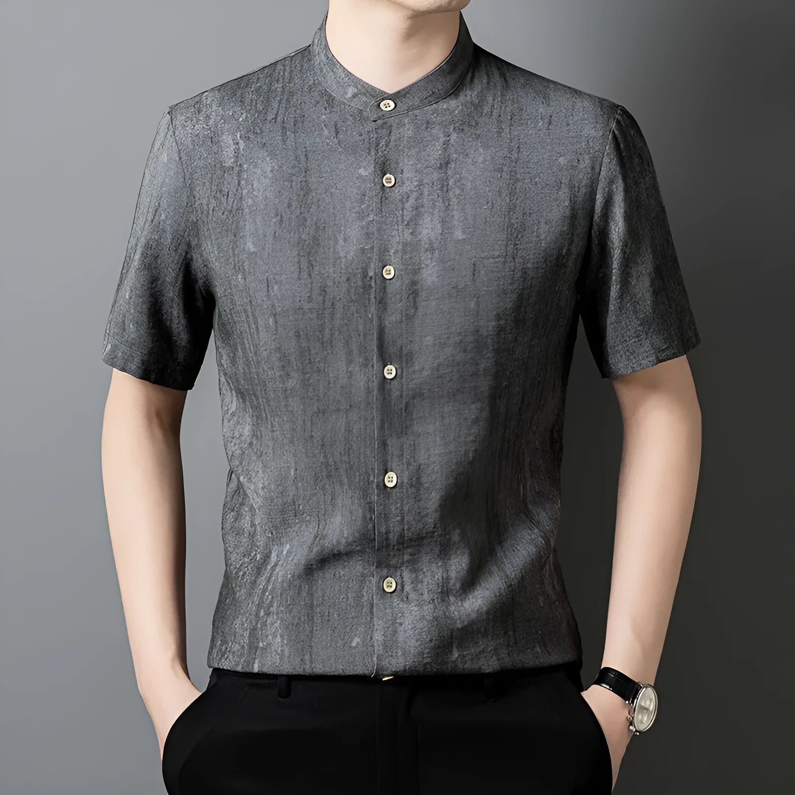 Man wearing a loose-fit black grey linen cardigan-style shirt with a stand collar and short sleeves.