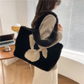 Soft plush tote bag with cartoon rabbit ears on the front in a solid colour.
