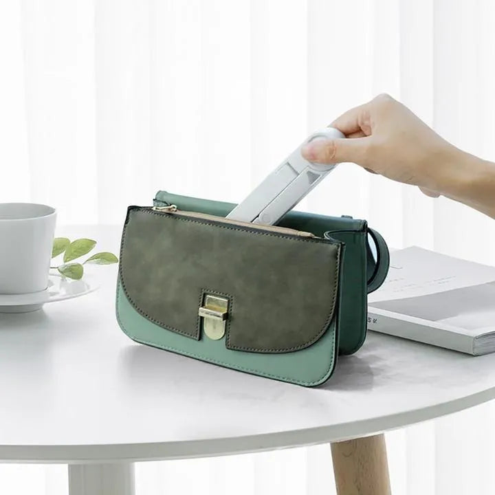 Black foldable tablet holder displaying a smartphone in landscape mode on a desk.