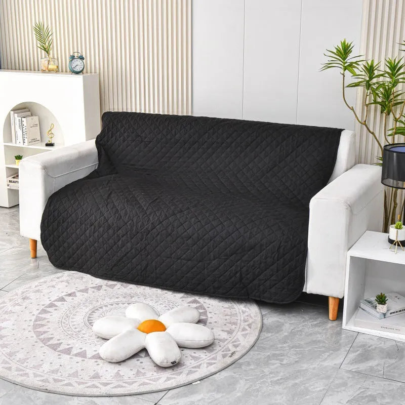Reversible waterproof dog blanket on sofa showing two colour options, protecting furniture from pet accidents
