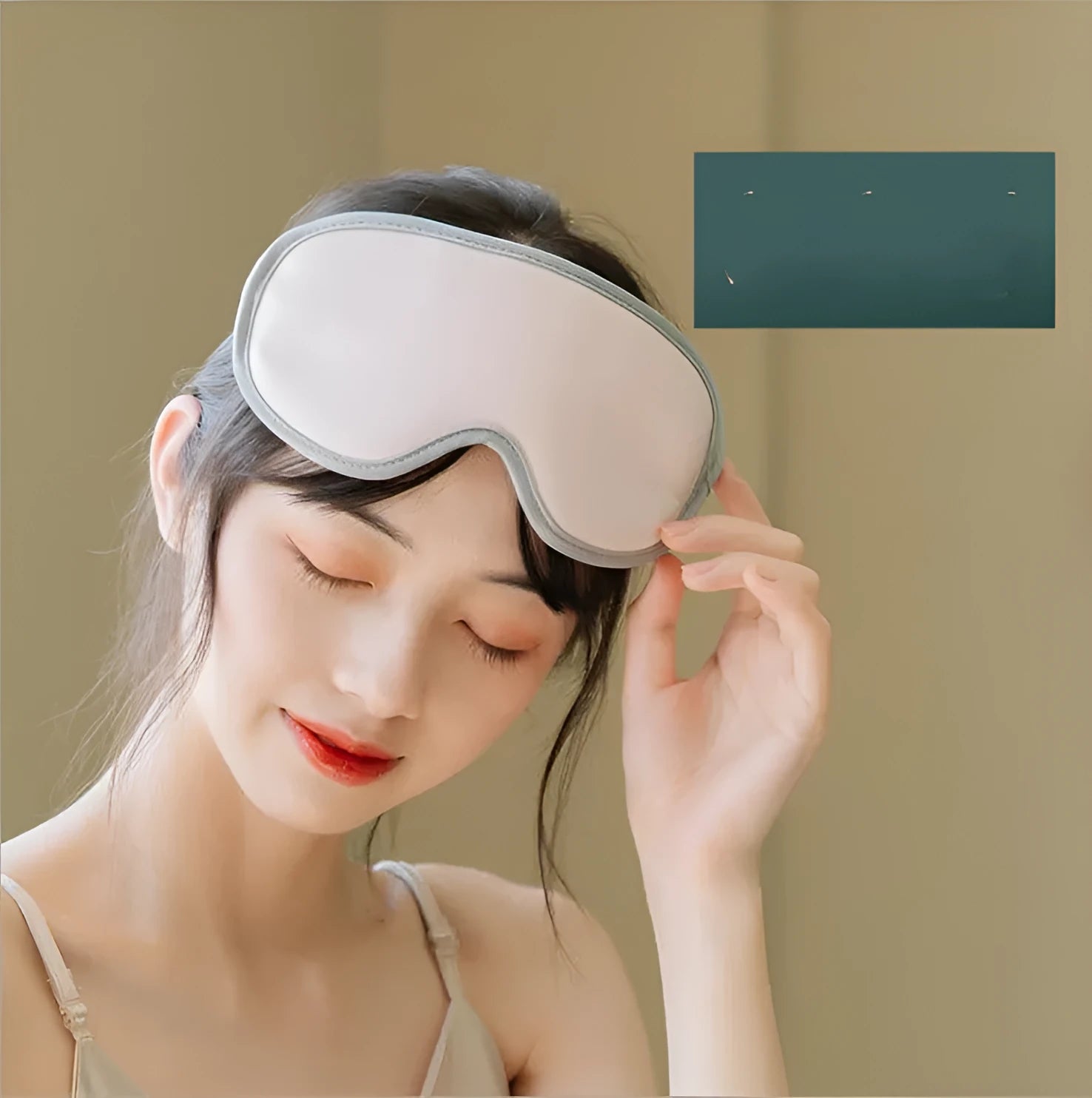 Portable green eye steam massage mask with USB cable on a grey background