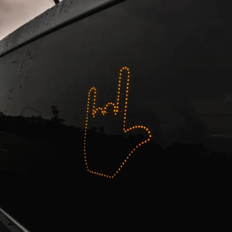 Black plastic LED gesture car light with remote control showing illuminated hand symbol.