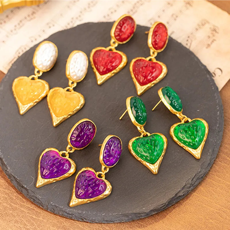 A pair of silver needle pleated oval love heart stud earrings in alloy metal, showing the textured surface and heart shape.