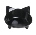 Four shallow black melamine pet bowls with non-slip rubber bases on a table.