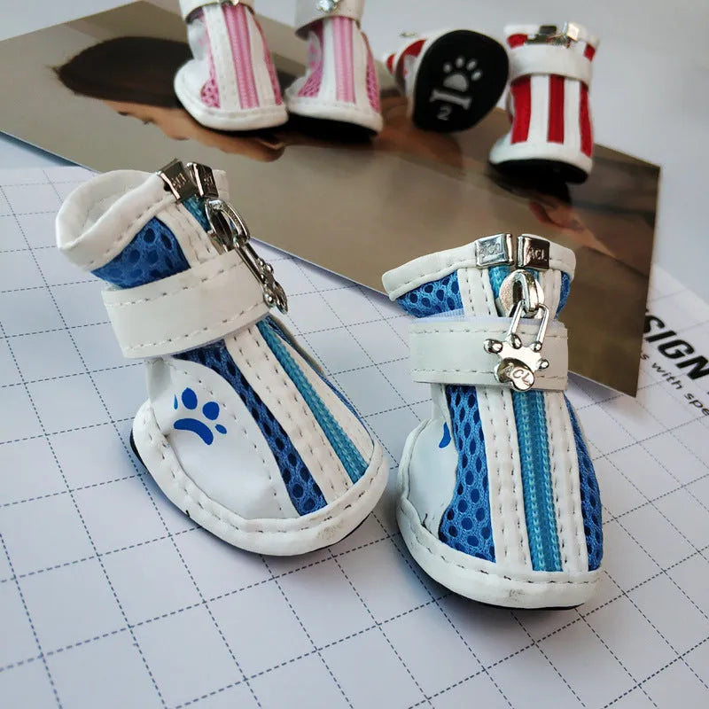 Blue zip-up dog shoes with a non-slip rubber sole, shown on a dog's paw.