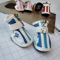 Blue zip-up dog shoes with a non-slip rubber sole, shown on a dog's paw.
