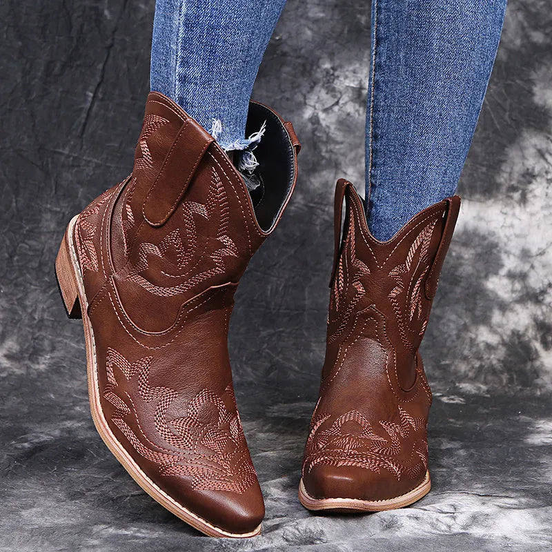 Women's blue cowboy boot with embroidery detail on the side, low wedge heel, and pointed toe.