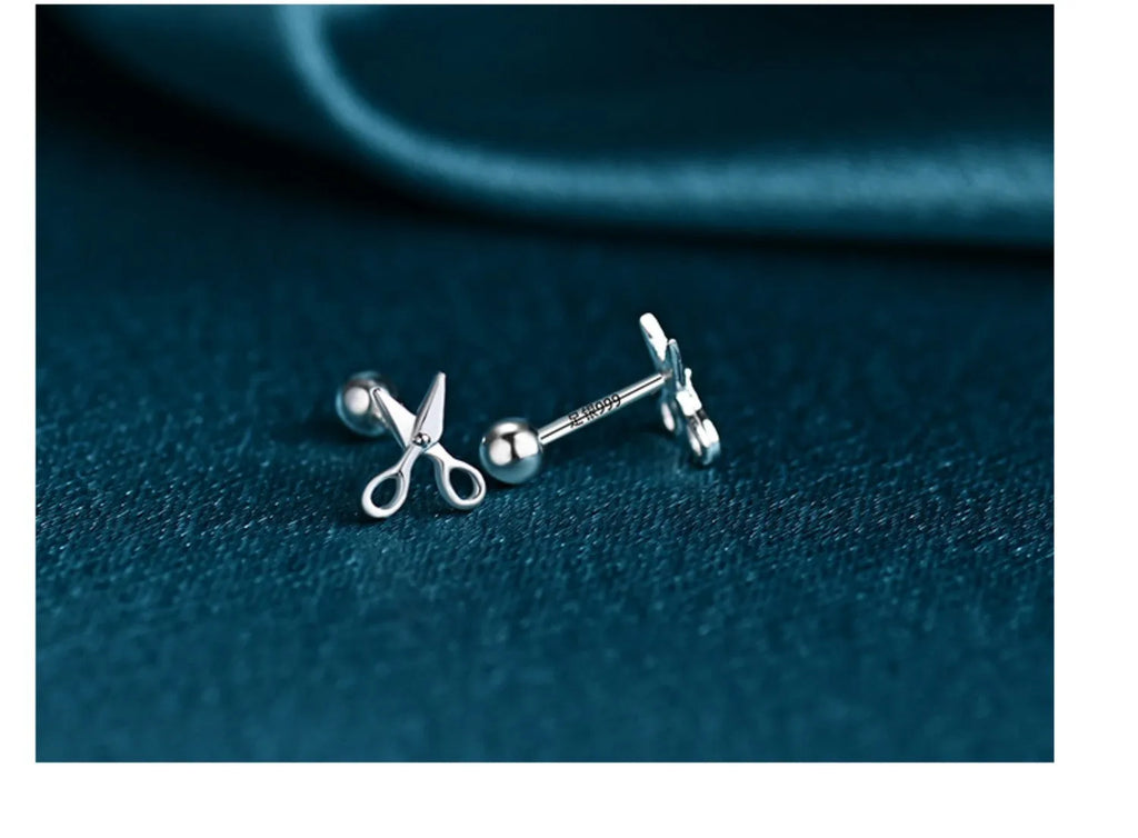 A pair of pure silver earrings with a mini scissors screws decorative design.