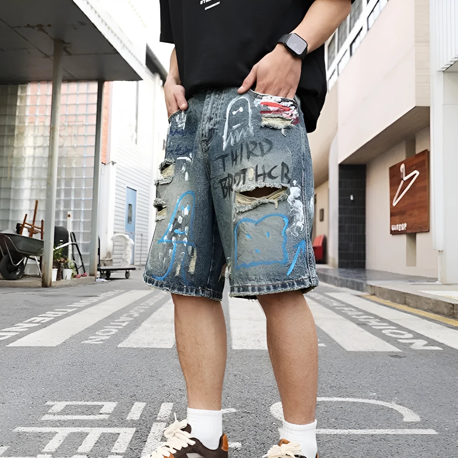 Men's blue ripped jeans shorts with graffiti detail, straight leg cut, and zipper fly closure