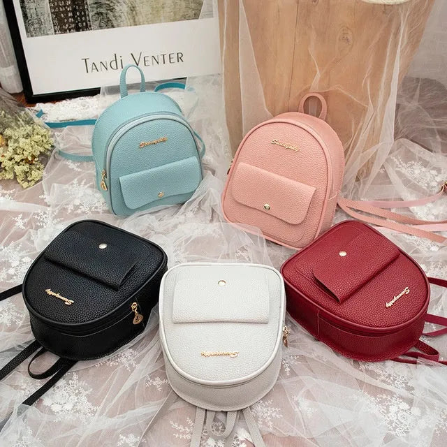 Small black PU leather ladies backpack with zipper, shown on shoulder