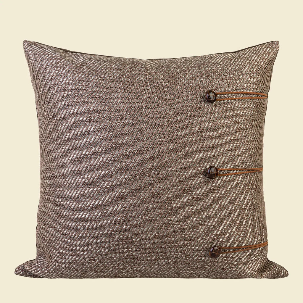 Square Chinese style cushion with geometric pattern in brown Maillard colour options on a sofa.