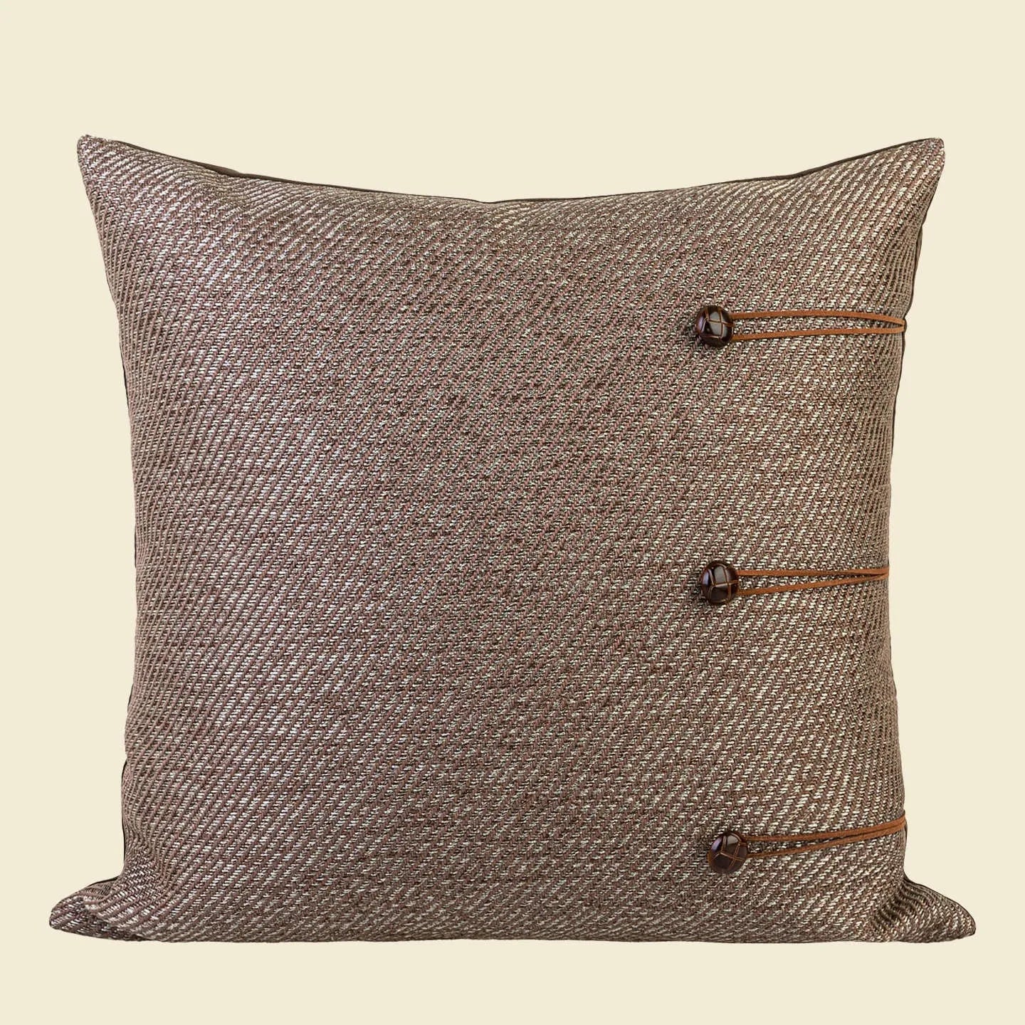 Square Chinese style cushion with geometric pattern in brown Maillard colour options on a sofa.