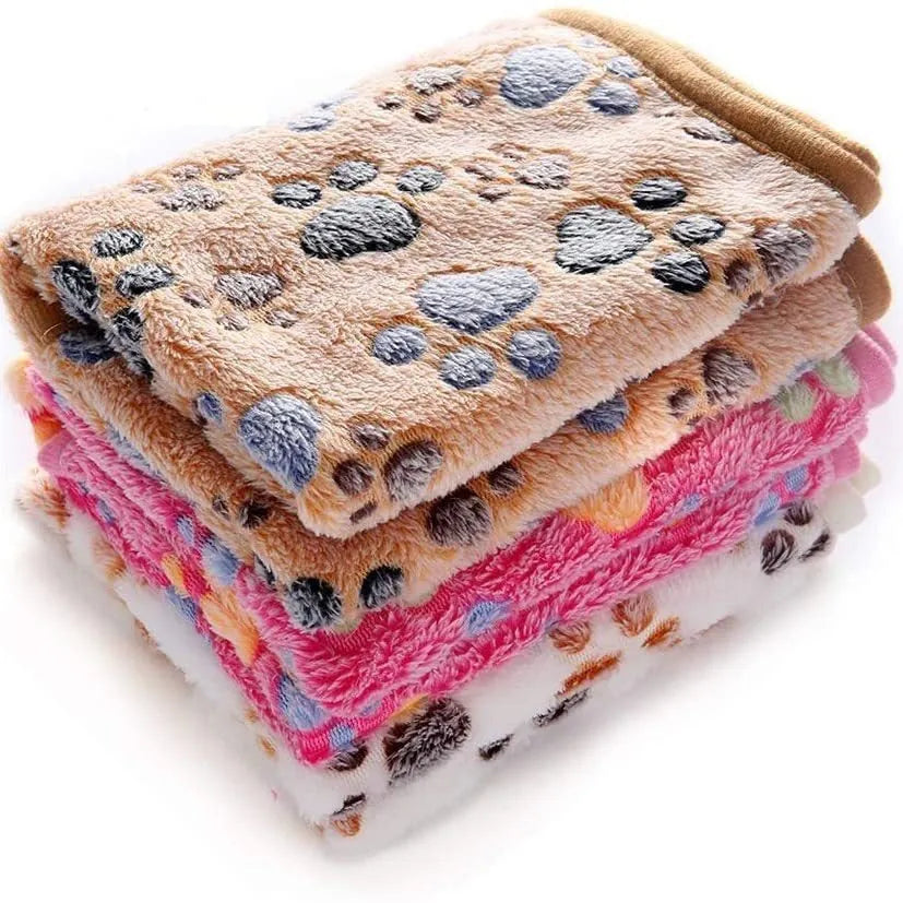 Soft coral fleece dog blanket with paw print design shown in beige colour on a dog bed.