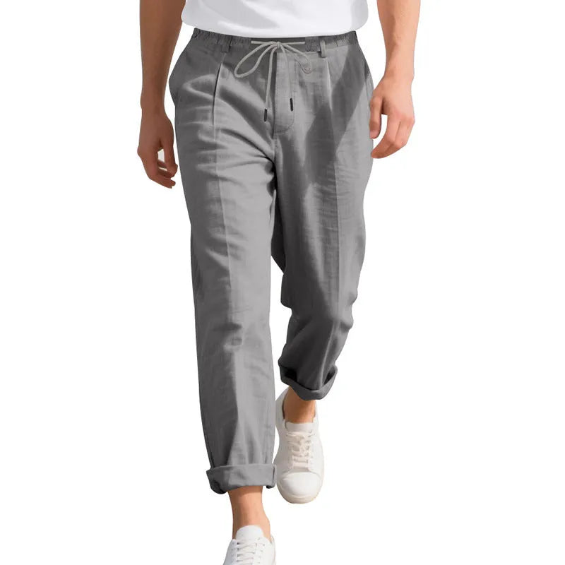 Men's light khaki linen casual trousers with a drawstring waist and straight leg fit.