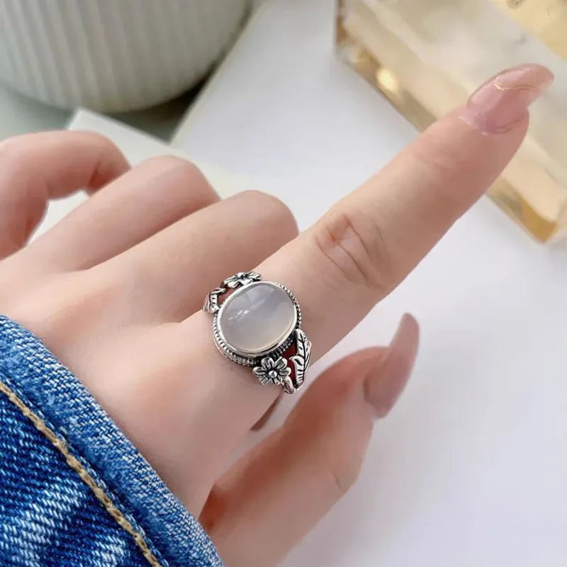 Adjustable vintage copper ring with a white imitation chalcedony stone on a U-shaped band.