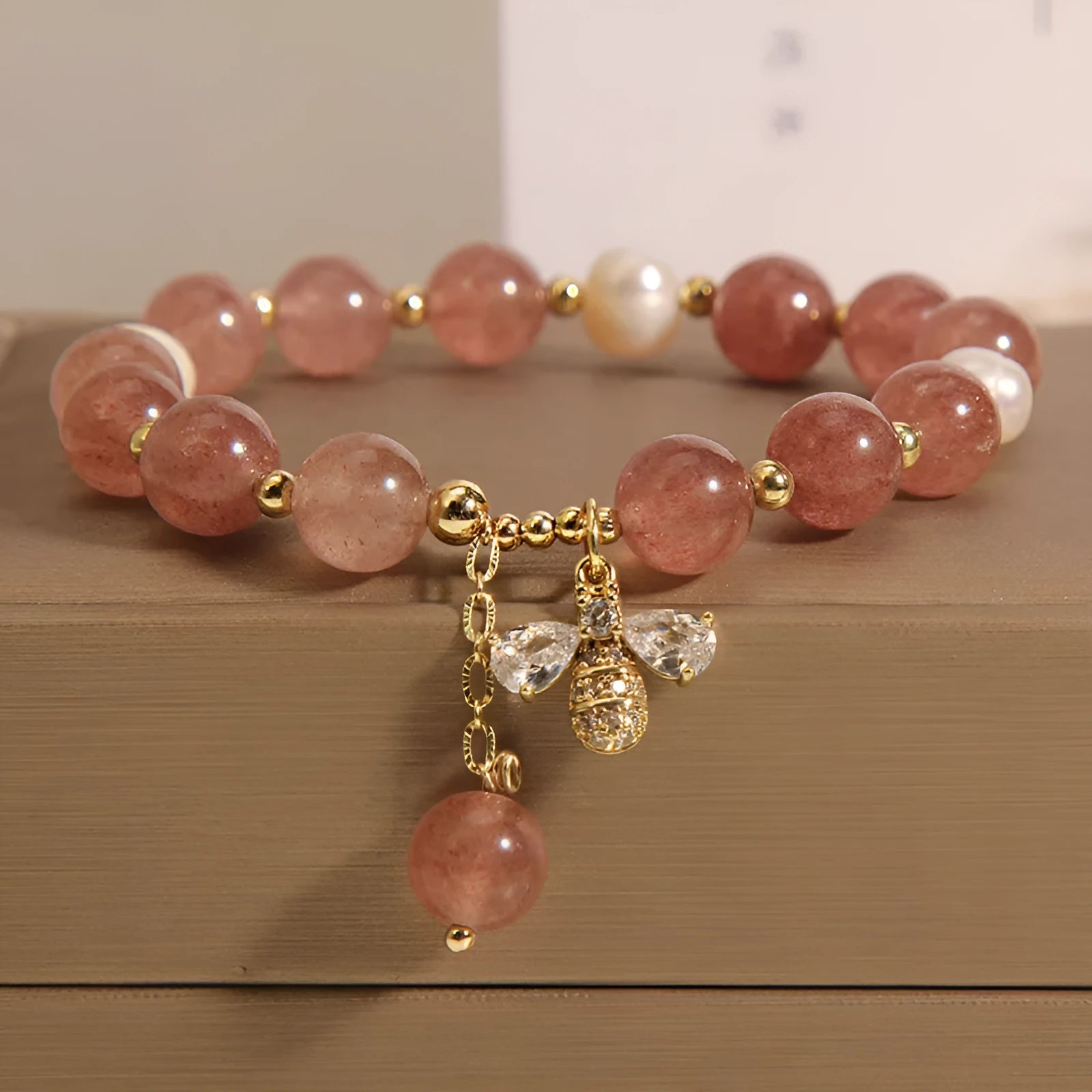 Women's pink strawberry quartz and white freshwater pearl bracelet with zircon accents on wrist